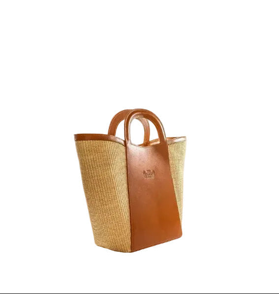 Shopper bag in natural color straw and camel leather. Top handles, adjustable and detachable crossbody strap. One inner pocket, magnetic closure. The Holy Bag
Γυναικεία τσάντα shopper από ταμπά δερμα και ψάθα σε φυσικό χρώμα, με αποσπώμενο λουράκι ώμου, εσωτερική τσέπη, κλείσιμο με μαγνήτη. Theholybag