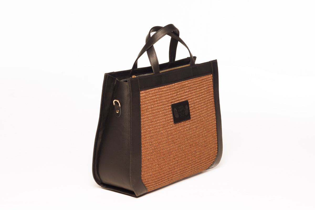 Tote bag in marrone straw and black leather. Two top handles and an adjustable shoulder strap. Closes with zipper. TheHolyBag  
Γυναικεία tote τσάντα από καφέ ψάθα και μαύρο δέρμα με top handles και αποσπώμενο λουράκι ώμου, με εσωτερική τσέπη. Κλείνει με φερμουάρ. The Holy Bag
