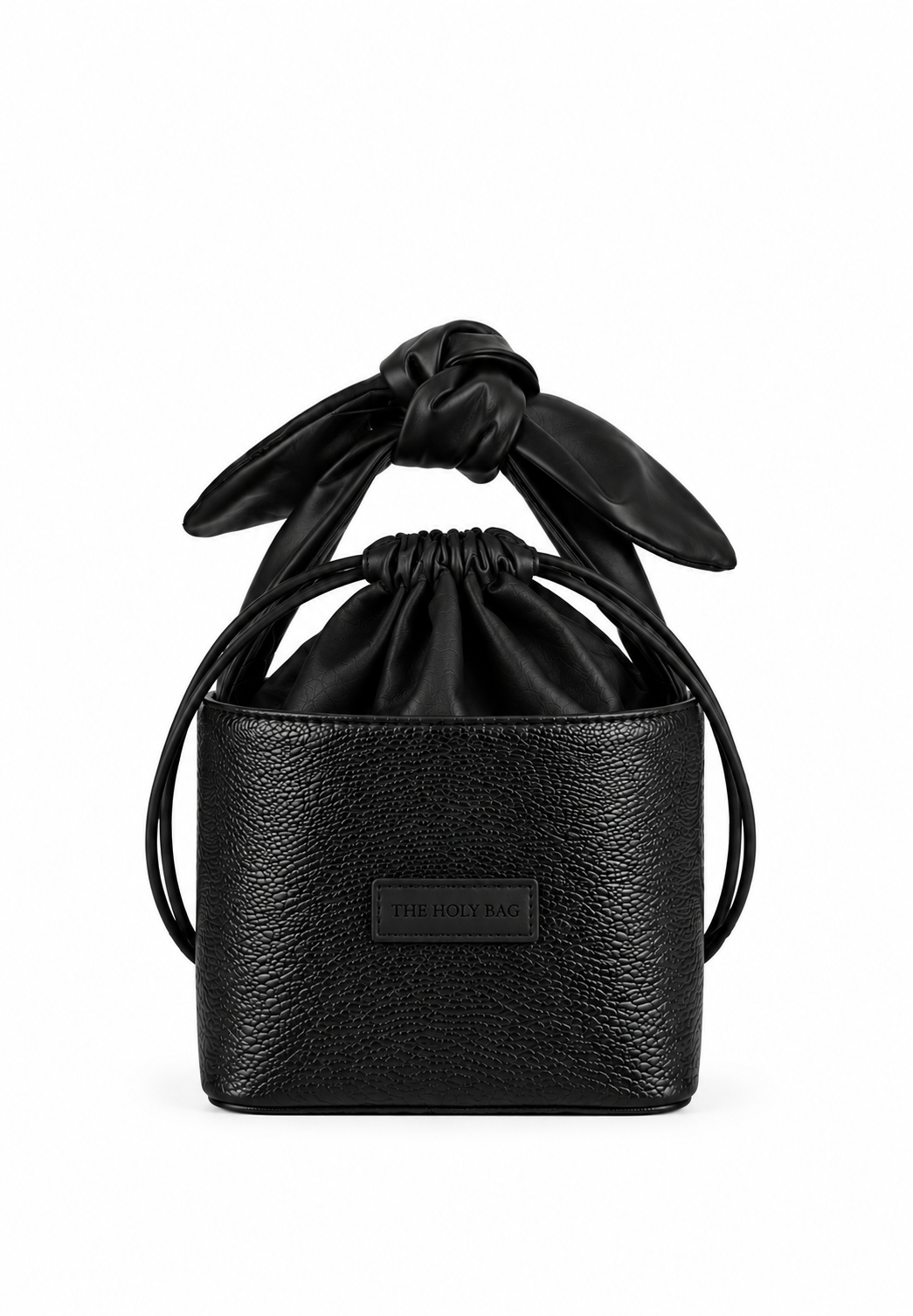 A black leather bucket bag with a drawstring cotton top and a knotted bow detail on the handle, featuring a small rectangular brand plaque on the front.