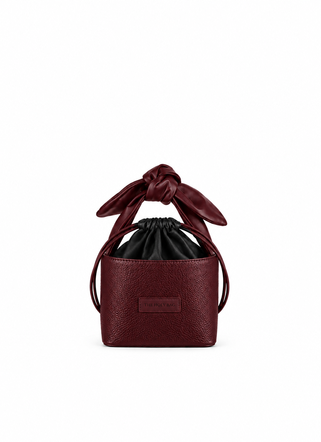 Ioli bucket bag in burgundy calf dollaro leather, with a cotton drawstring pouch and bow style lamp leather handle. Inner pocket and an adjustable shoulder strap.
Τσάντα-καλάθι από δέρμα μοσχάρι σε μπορντό χρώμα, με βαμβακερό πουγκί και λαβή φιόγκο, από μαλακό δέρμα από αρνί και αποσπώμενο λουράκι ώμου που αυξομειώνεται. The Holy Bag