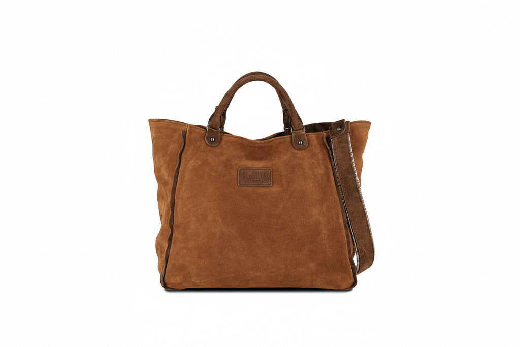 Tote bag in brown suede details, a detachable shoulder strap and two inner pockets. Closes with zipper.
Side strap that cinches the sides of the bag. The Holy Bag
Τσάντα tote από ψάθα και σουέντ λεπτομέρειες. Με μία τσέπη με φερμουάρ και μία ανοιχτή, με αποσπώμενο λουράκι ώμου από ιμάντα με σουέντ και κλείσιμο επάνω με φερμουάρ. Εσωτερικό λουράκι που μαζεύει τις πλαινές πλευρές της τσάντας. The Holy Bag