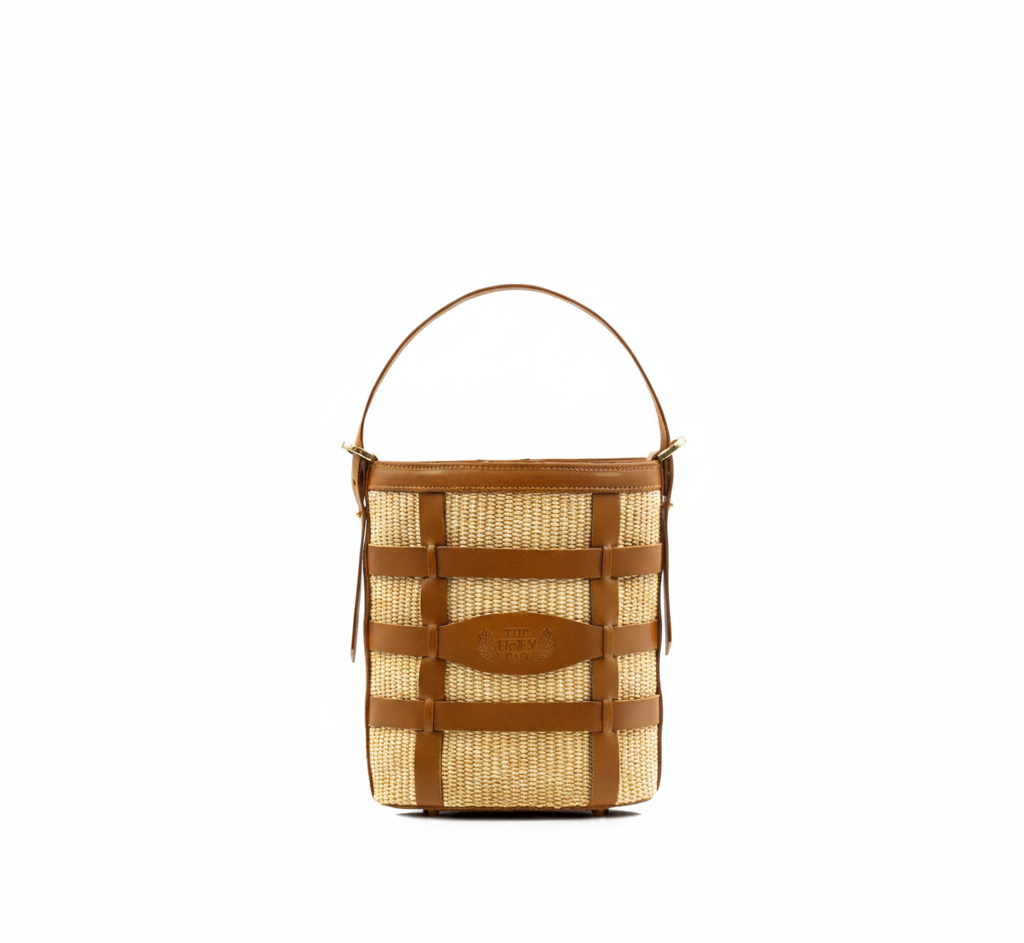 Theholybag Γυναικεία bucket τσάντα  από ψάθα σε φυσικό χρώμα και ταμπά δέρμα πλεγμένο στο χέρι, με ένα top handle, Meltemi.
Women bag in natural color straw and knitted in hand tobacco leather, Meltemi. The Holy Bag