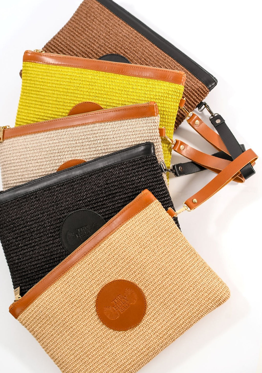 Clutch bag in fresh colors, with a zipper and a side wrist handle. 
TheHolyBag 
Τσαντάκι από ψάθα και δερμάτινες λεπτομέρειες, με αποσπώμενο λουράκι για το χέρι. Με βαμβακερή επένδυση. Σε 5 χρώματα. The Holy Bag