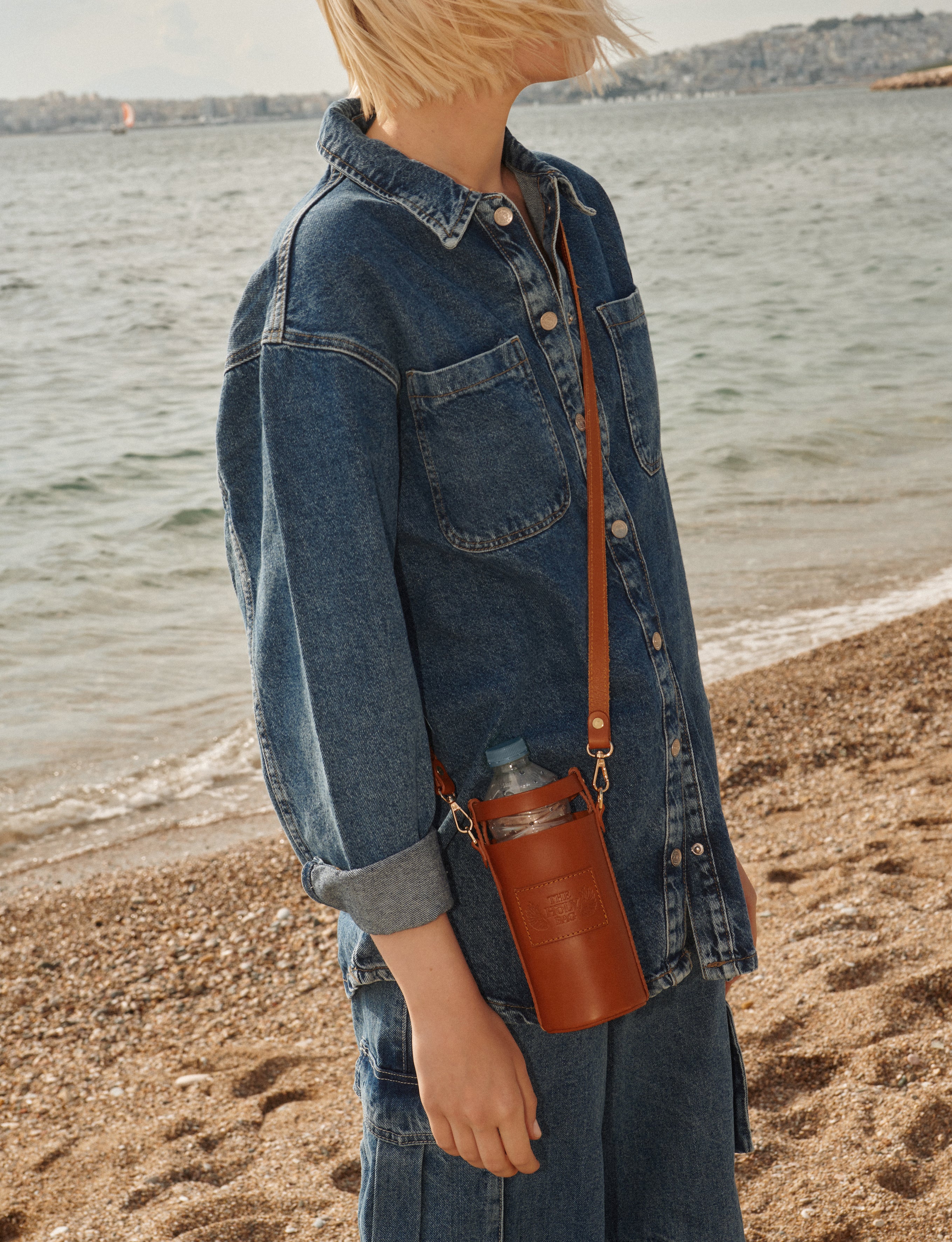 TheHolyBag Bottle case, τσαντάκι-θήκη μπουκαλιού από δέρμα ταμπά, με λουράκι. Φοριεται στον ώμο ή χιαστί.