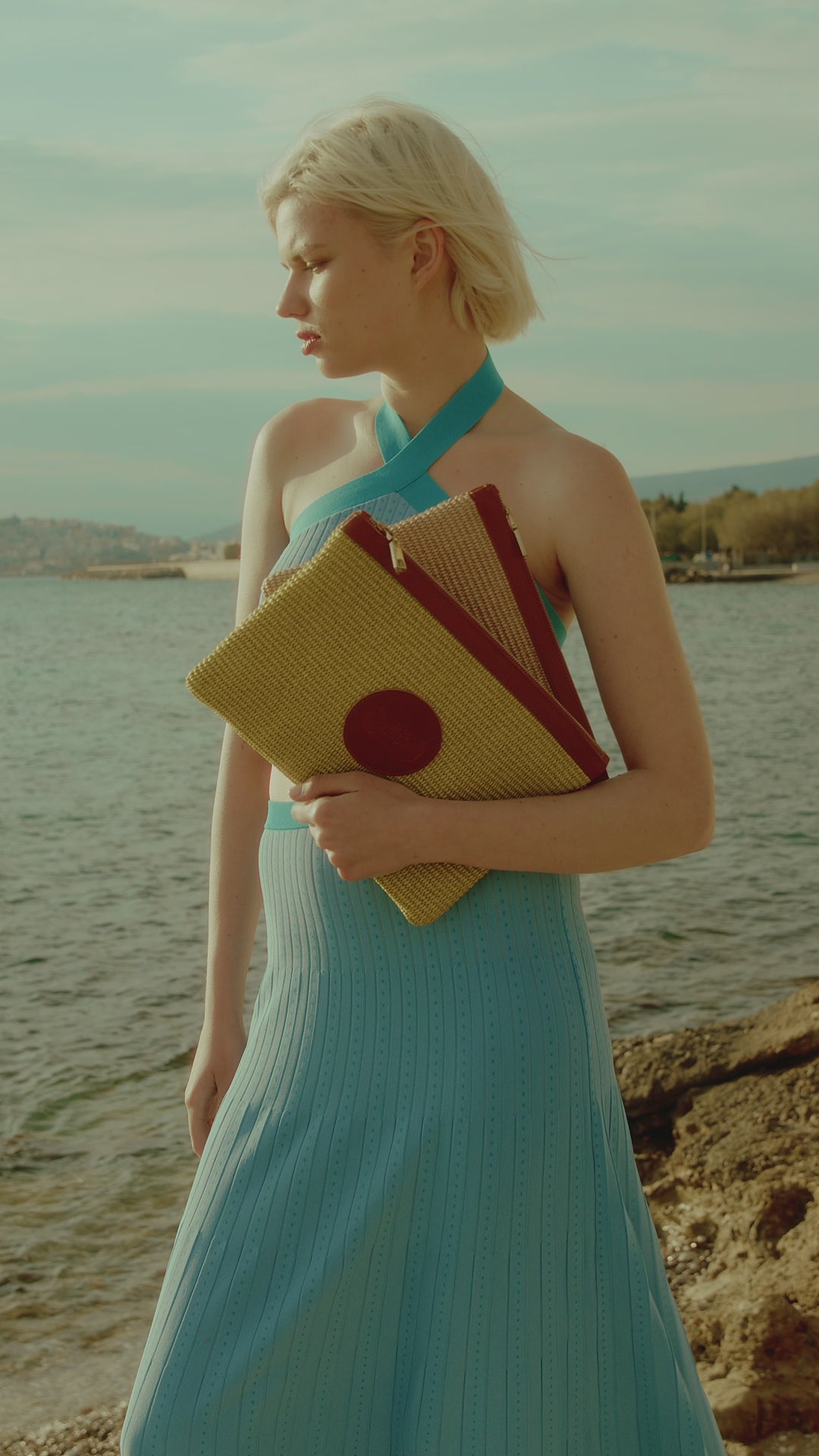 TheHolyBag  Clutch γυναικείο τσαντάκι από ψάθα σε φυσικό χρώμα και μαύρο δέρμα με λουράκι χειρός στο πλάι. Κλείνει με φερμουάρ.