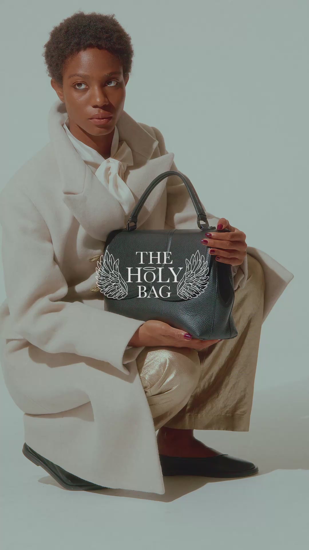 TheHolyBag Βίντεο Tote τσάντα σε μαύρο δέρμα με top handle και αποσπώμενο λουράκι ώμου. Με ασύμμετρο καπάκι. Κλείνει με μαγνήτη και διαθέτει εσωτερική τσέπη.