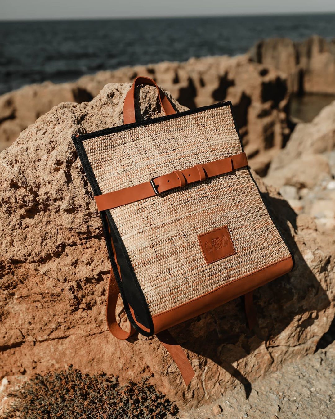 TheHolyBag Unisex σακίδιο πλάτης σε μαύρο δέρμα και ψάθα, με top handle και οριζόντιο λουράκι για εξτρα ασφάλεια. Με λουράκια πλάτης που αυξομειώνονται. 